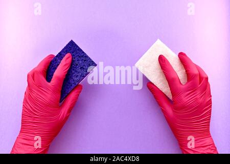 Washing sponges, with a soft and abrasive delicate surface, in the hands in latex gloves, on a purple background. Stock Photo