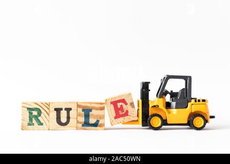 Toy forklift hold wood letter block e to complete word rule on white background Stock Photo