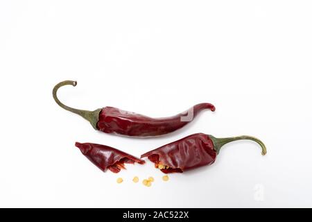 Dry red pepper pod with seeds on a white background. Broken dry pod in half Stock Photo