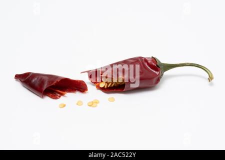 Dry red pepper pod with seeds on a white background. Broken dry pod in half Stock Photo
