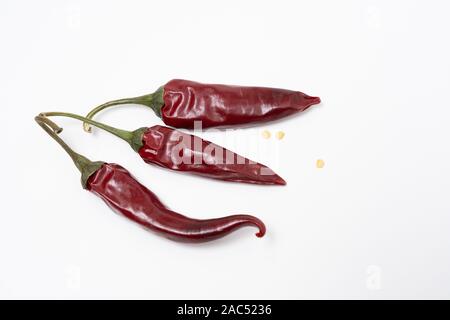 Three red hot chili peppers on a white background. Stock Photo
