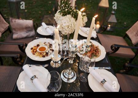 Close up top view of the served table with lighted candles and food Stock Photo