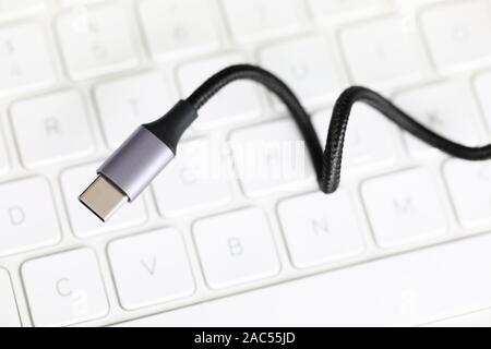 Usb type c cable against laptop keyboard background. Stock Photo