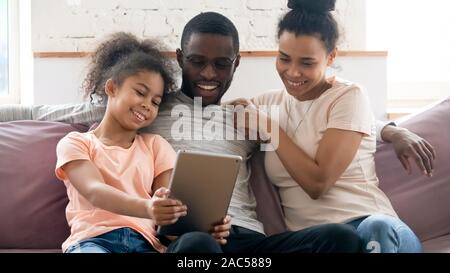 Happy biracial family with kid watch video on tablet Stock Photo
