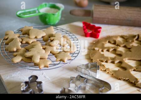 Using Christmas shaped cookie cutters to make gingerbread biscuits at Christmas Stock Photo