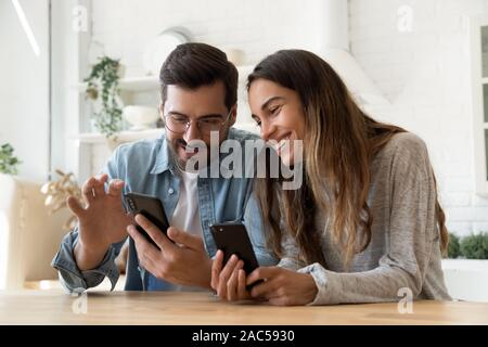 Young couple using smartphones share social media news at home Stock Photo