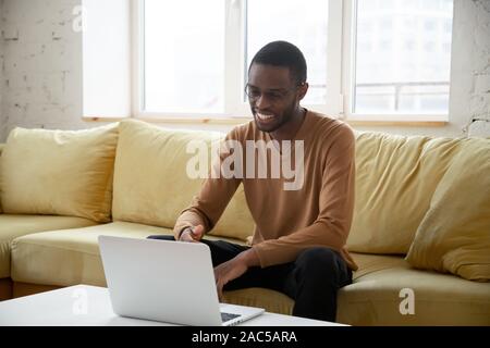 Smiling african American man having video call on laptop Stock Photo