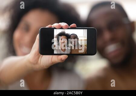 Smiling biracial couple making self-portrait picture on cell together Stock Photo