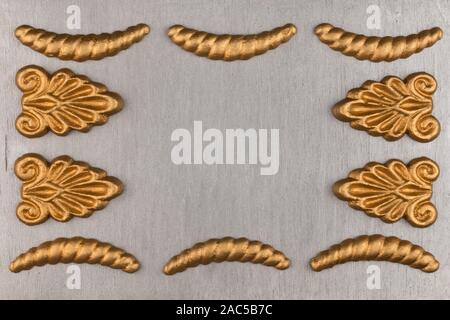 Luxury frame made of golden stucco plaster lying on silver surface. Text place, copy space. Top view. Fashion background Stock Photo