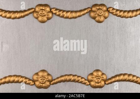 Luxury frame made of golden stucco plaster lying on silver surface. Text place, copy space. Top view. Fashion background Stock Photo