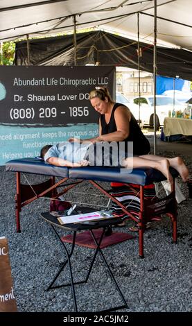 Chiropractic care by Dr. Shauna Lover at the Hilo Farmers Market, Big Island of Hawai'i. Stock Photo