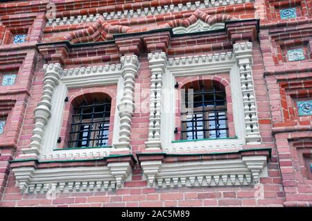 Part of the wall of the facade of a medieval building with barred windows Stock Photo