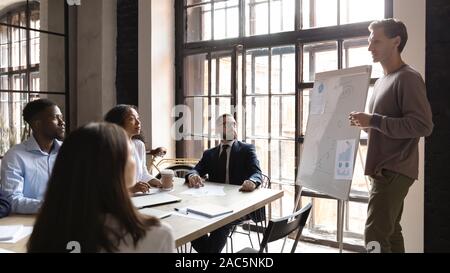 Focused mixed race young managers listening to colleague. Stock Photo