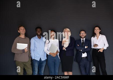 Portrait of happy mixed race older and young employees. Stock Photo