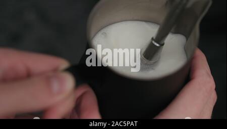 closeup man steaming in black pitcher, wide photo Stock Photo