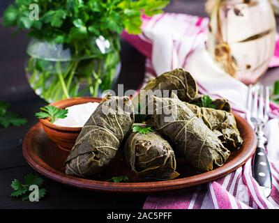 Dolma. Stuffed grape leaves with rice and meat on dark table. Middle eastern cuisine. Stock Photo