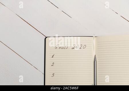 Top view composition with journal with handwritten words "Goals 2020" Stock Photo