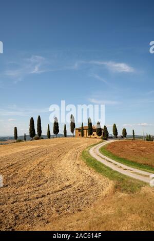 A summer holiday home farmhouse in the Tuscan landscape with cypress trees near Pienza Tuscany Italy Europe Stock Photo