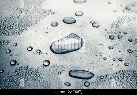 Water drops on rough silvery background, close-up Stock Photo