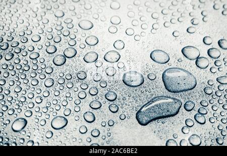 Water drops on rough silvery background, close-up Stock Photo