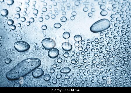 Water drops on rough silvery background, close-up Stock Photo