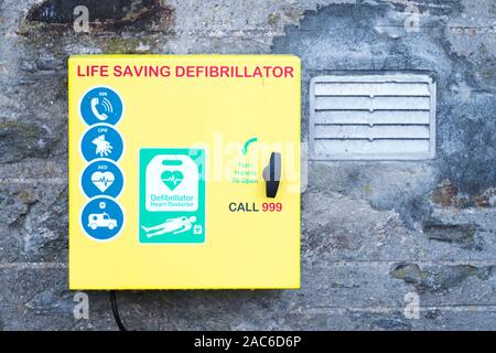 Defibrillator AED on wall for public use in a town England to save life Stock Photo