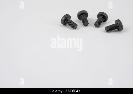 Black metal screws arranged in semicircle on white background Stock Photo