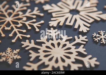 Handmade wooden snowflakes in flay lay on blue Christmas