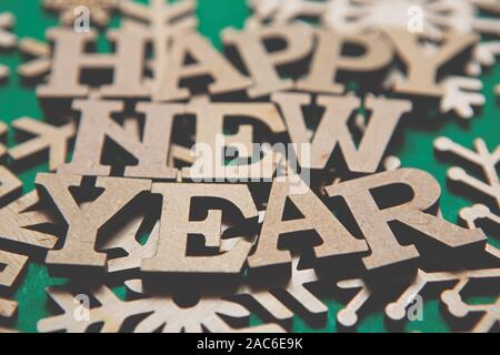 Green Happy New Year background.Wooden alphabet letters and hand made snow flakes made from natural ecological material.Eco friendly home decor for wi Stock Photo