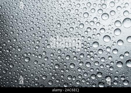 Water drops on rough silvery background, close-up Stock Photo