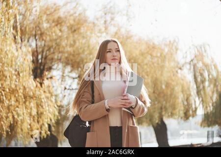 Pure beauty. Portrait of young blonde girl that having rest while walking in autumn park Stock Photo