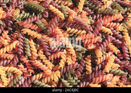 Uncooked tricolore fusilli pasta twist shapes background. Stock photo pasta twist shapes. Stock Photo