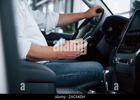 Particle view. Using mobile phone. Businessman sits in the modern car and have some deals Stock Photo