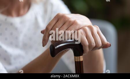 Close up concept image old woman holding walking stick Stock Photo