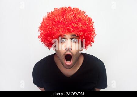 Portrait of overwhelmed shocked man with bristle and red wig staring in surprise at camera, screaming in amazement and delight, disbelief reaction. in Stock Photo