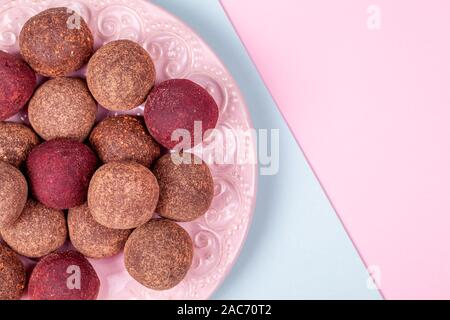 Homemade Raw Energy Balls on Vintage Plate on Blue and Pink Paper Background Stock Photo