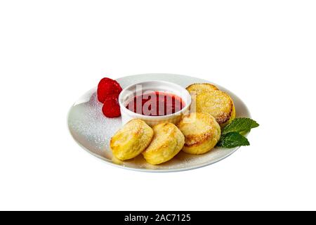 Gourmet breakfast - cottage cheese pancakes, cheesecakes, cottage cheese pancakes with strawberries, mint and powdered sugar in a white plate. Useful Stock Photo
