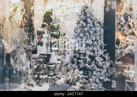 View of a shop full of beautiful adorns for Christmas and New Year eve holiday. Many decorations with christmas tree, baubles, lights, snowflakes and Stock Photo
