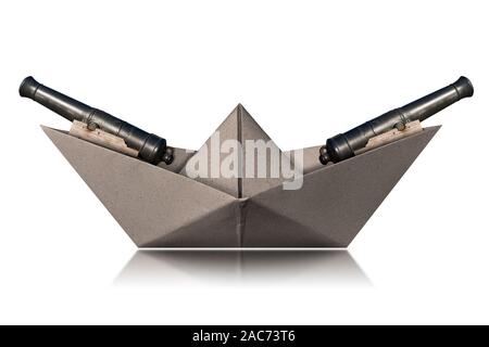 Warship with two old cannons, small paper boat isolated on white background with reflections, photography Stock Photo