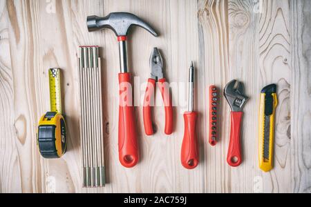 Hand tools set red and yellow color on wood, top view. DIY, repair, service concept. Stock Photo