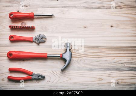 Hand tools set red color on wood, copy space, top view. DIY, repair, maintenance concept Stock Photo