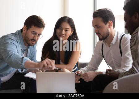 Team leader explain to diverse colleagues corporate program using notebook Stock Photo