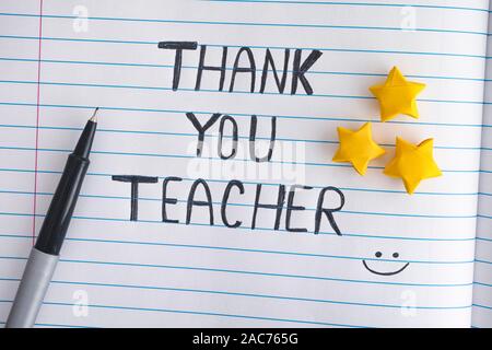 Thank You Teacher. Lined paper notepad with origami stars and words Thank You Teacher. Close up. Stock Photo