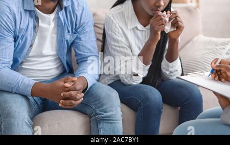 Unrecognizable Black Couple Sitting On Couch At Marital Counselor's Office Stock Photo