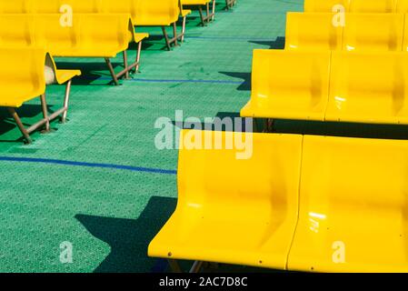 Rows of empty yellow seats in front of green plastic floor on the upper deck of a Jadrolinija ferry in Croatia Stock Photo