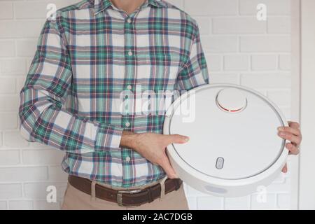 Man with a new robot with a vacuum cleaner in his hands Stock Photo