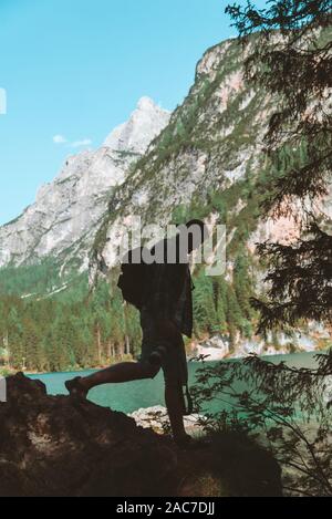 man climbing by rocks to shoot beautiful landscape of lake and mountains Stock Photo