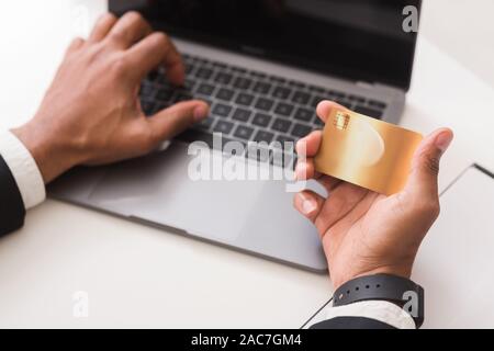 Hands of man typing credit card number on laptop Stock Photo