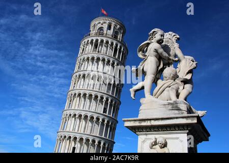 The iconic Leaning Tower of Pisa and nearby Statue of Angels standing against a blue sky backdrop, Campo dei Miracoli, Pisa, Tuscany, Italy, Europe. Stock Photo