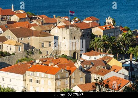 View of the city gate, the medieval streets and buildings of the historic old town of Korcula in front of the island of Peljesac at sunset, Croati Stock Photo